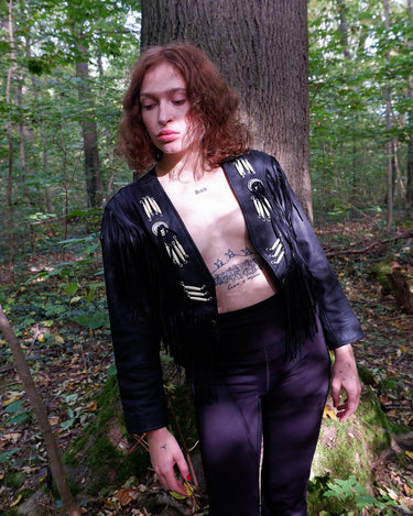 Unleash your inner rebel with this vintage 80s black leather crop fringe jacket. Made from high-quality leather, this XS jacket features fringe detailing that will make a statement. 