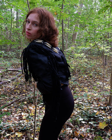 Unleash your inner rebel with this vintage 80s black leather crop fringe jacket. Made from high-quality leather, this XS jacket features fringe detailing that will make a statement. 