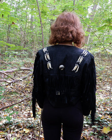 Unleash your inner rebel with this vintage 80s black leather crop fringe jacket. Made from high-quality leather, this XS jacket features fringe detailing that will make a statement. 