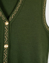a woman is wearing a vintage 90s long green vest with golden details.