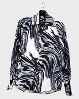 This black and white shirt doesn’t ask for attention — it just gets it. The abstract swirl pattern gives effortless chaos in the best way possible. Throw it on and let the print do the talking!