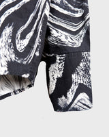 This black and white shirt doesn’t ask for attention — it just gets it. The abstract swirl pattern gives effortless chaos in the best way possible. Throw it on and let the print do the talking!