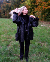 Experience timeless style with this Vintage 80s black faux leather shearling coat, featuring a warm lining that will keep you cozy. Just a heads up, the sleeves are not lined for extra warmth.