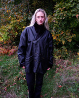 Experience timeless style with this Vintage 80s black faux leather shearling coat, featuring a warm lining that will keep you cozy. Just a heads up, the sleeves are not lined for extra warmth.