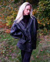 Experience timeless style with this Vintage 80s black faux leather shearling coat, featuring a warm lining that will keep you cozy. Just a heads up, the sleeves are not lined for extra warmth.