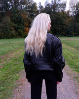 This vintage 90s black bomber jacket is a unisex must-have for any wardrobe! Made from heavy leather, this jacket boasts a timeless look with a touch of edge.