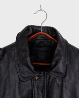 This vintage 90s black bomber jacket is a unisex must-have for any wardrobe! Made from heavy leather, this jacket boasts a timeless look with a touch of edge.