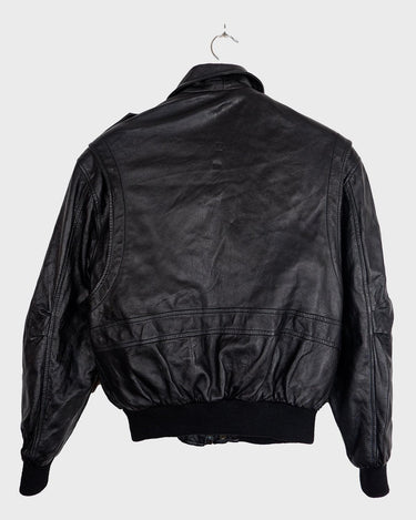 This vintage 90s black bomber jacket is a unisex must-have for any wardrobe! Made from heavy leather, this jacket boasts a timeless look with a touch of edge.