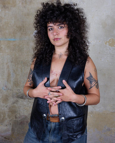 Embrace your inner rebel with this vintage 80s 90s black biker leather vest! Perfect for adding a touch of edge to any outfit, this vest is full of personality and attitude. Made with genuine leather, it offers both style and durability.