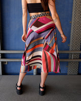 This Y2k skirt serves pure elegance with its flowing silhouette and vibrant geometric print in magenta, teal, orange, and warm brown. Light and easy to wear, it’s comfortable and anything but boring—designed for those who dress with intention.