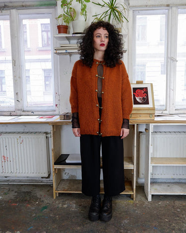 Add a playful touch to your wardrobe with this vintage 80s brown woolmix cardigan, handmade with love. The 3/4 sleeve length and golden buttons make it stand out from the rest.