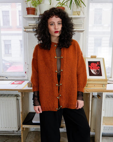 Add a playful touch to your wardrobe with this vintage 80s brown woolmix cardigan, handmade with love. The 3/4 sleeve length and golden buttons make it stand out from the rest.