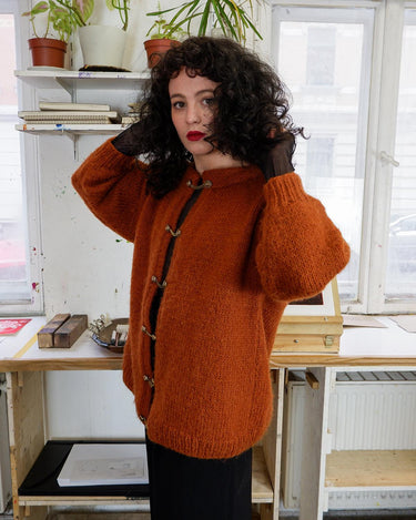 Add a playful touch to your wardrobe with this vintage 80s brown woolmix cardigan, handmade with love. The 3/4 sleeve length and golden buttons make it stand out from the rest.