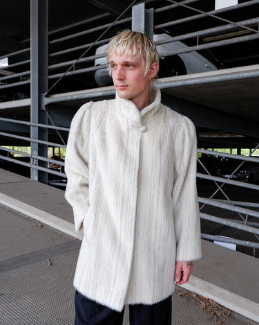 Wrap yourself in timeless elegance with this vintage off-white alpaca and mohair coat by AlmoFlor. Featuring a luxurious soft texture and subtle vertical stripe detailing, this piece exudes classic sophistication and understated glamour.