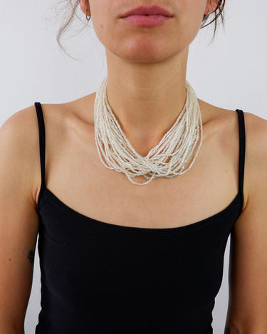 a woman is wearing a Vintage multi-strand fairy-core pearl-style costume jewelry necklace from the online shop vinti vintage