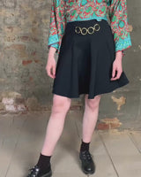 This vintage 90s mini skirt with bold gold ring details is a true statement piece with attitude. Vintage, but made for now.
