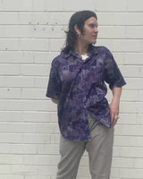 Bold, breezy, and silky smooth - this rare 90s short-sleeve gem by T. Corner is made from real Thai silk, brought to you by one of Thailand’s most renowned silk producers. The glossy fabric pops with a crazy pattern in electric purples and blues that’s impossible to ignore. Wear it loud, wear it proud