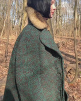 Experience true vintage elegance with this stunning green wool coat from the 70s/80s. Beautiful brown accents add a stylish touch, while the real fur collar adds a luxurious and statement-making element.
