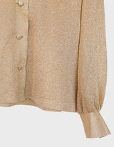 a woman is wearing a glitter blouse.
