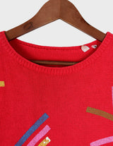 a woman is wearing a vintage 70s 80s red slipover.