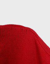 a woman is wearing a vintage 70s 80s red slipover.