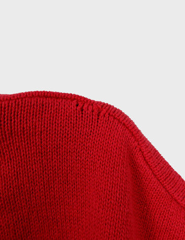 a woman is wearing a vintage 70s 80s red slipover.