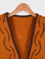 a woman is wearing a brown vest.