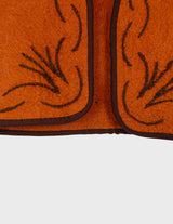 a woman is wearing a brown vest.