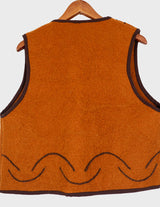 a woman is wearing a brown vest.