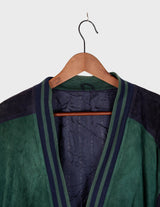 a man is wearing a 80s vintage green jacket.