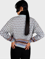 a woman is wearing a light blue vintage sweater.