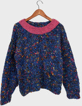 a woman is wearing a handknitted sweater.