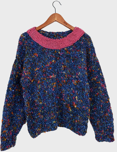 a woman is wearing a handknitted sweater.