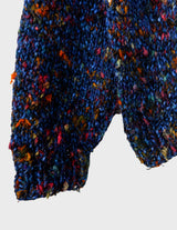 a woman is wearing a handknitted sweater.