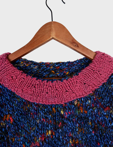 a woman is wearing a handknitted sweater.
