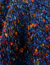 a woman is wearing a handknitted sweater.