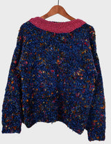 a woman is wearing a handknitted sweater.