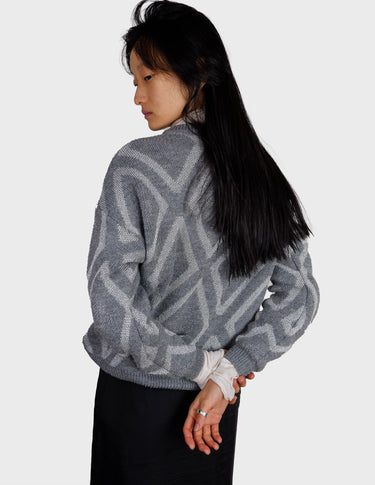 a woman is wearing a 80s vintage glitter sweater.