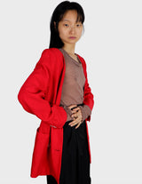 a woman is wearing a red 80s vintage blazer.