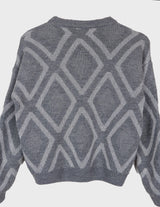 a woman is wearing a 80s vintage glitter sweater.