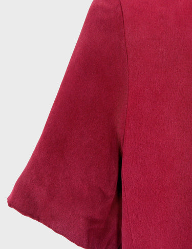 a woman is wearing a 90s burgundy shirt.
