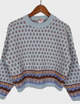 a woman is wearing a light blue vintage sweater.