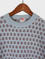 a woman is wearing a light blue vintage sweater.