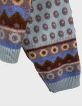 a woman is wearing a light blue vintage sweater.