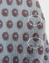 a woman is wearing a light blue vintage sweater.