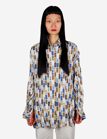 a woman is wearing a arty look blouse.