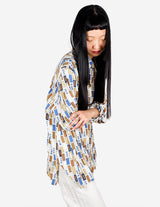 a woman is wearing a arty look blouse.