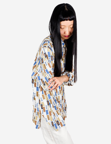 a woman is wearing a arty look blouse.