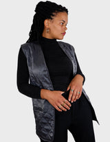 a woman is wearing a silver quilted vest.