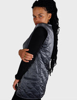 a woman is wearing a silver quilted vest.